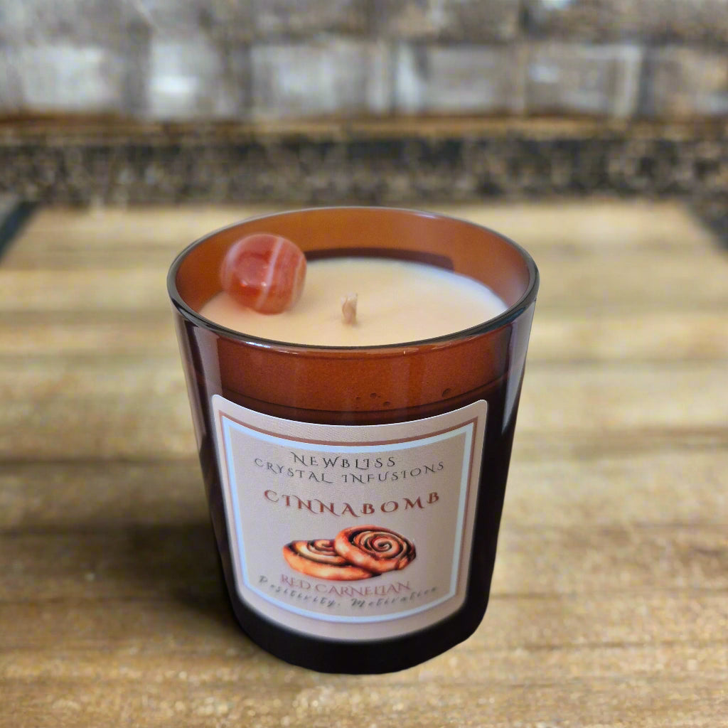 Cinnabomb candle in a glass jar on a wooden surface