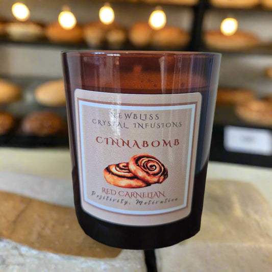 Candle of Crystal Infusions Cinnabomb with a label on a wooden surface